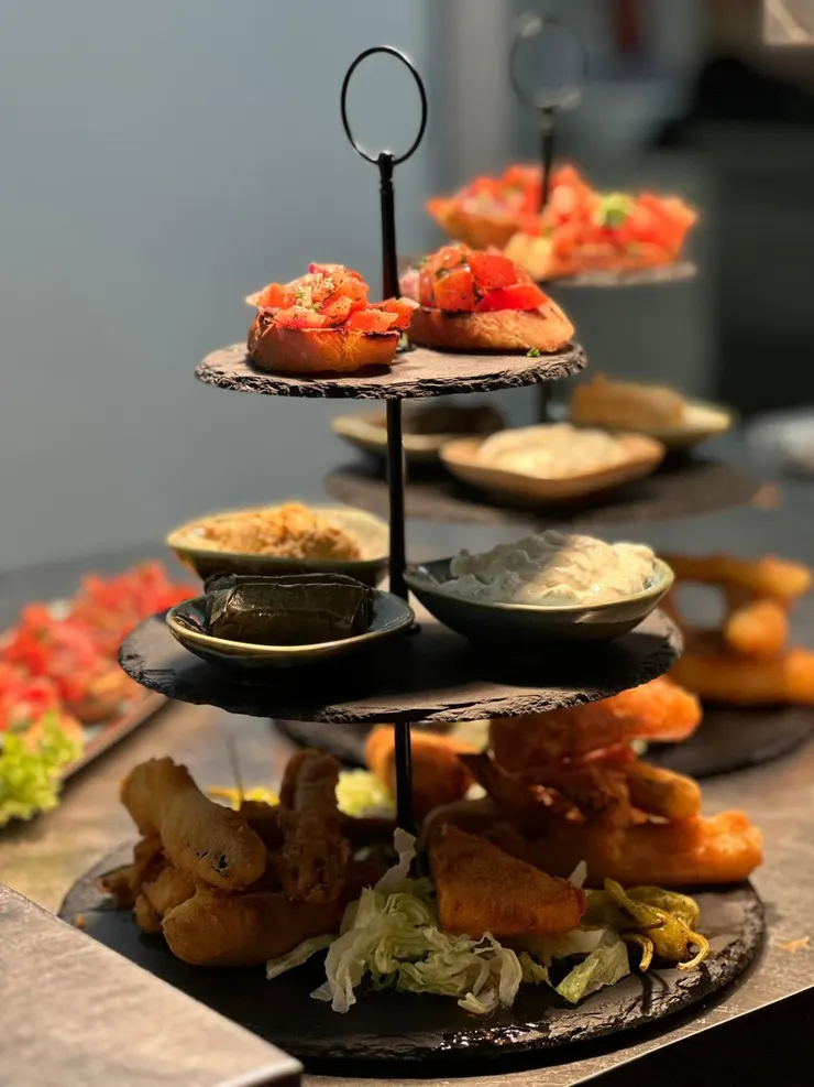 Dreistöckige Etagere mit Bruschetta, gefüllten Weinblättern und Dips
