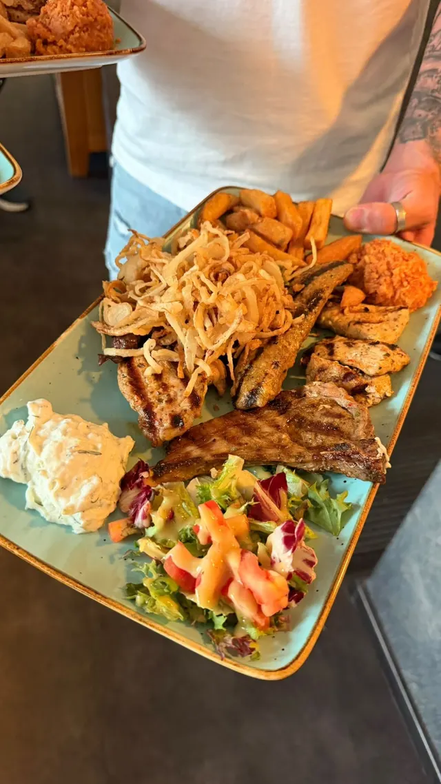 Gemischter Grillteller mit Röstzwiebeln, Pommes, Tomatenreis, Zaziki und Salat