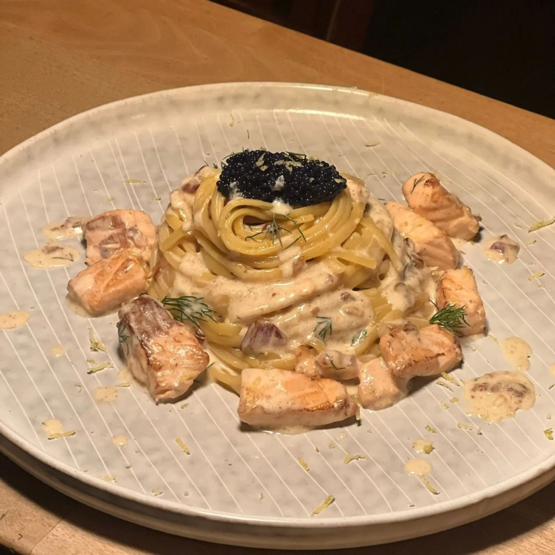 Linguine in Sahnesauce mit gebratenen Lachs-Stücken und schwarzem Kaviar