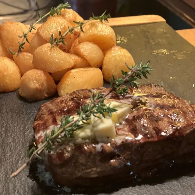Gebratenes Steak mit Kräuterbutter, Thymian und gerösteten Kartoffeln