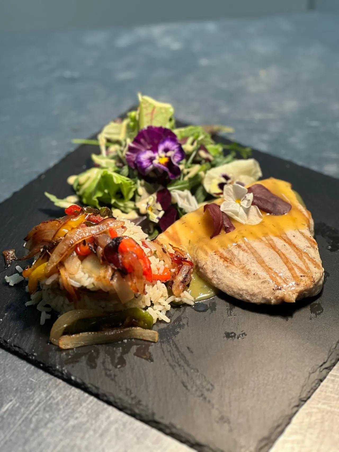 Gegrilltes Steak mit gelber Sauce, Reis mit Paprika und Zwiebeln sowie grüner Beilagensalat